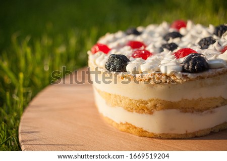 cake on wooden stand on grass background