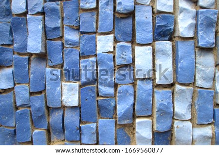 Blue bricks of different sizes and shapes. Inhomogeneous wall with decorative elements made of minerals. Solid material background in blue tones for decoration, presentations and design.