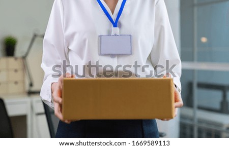 Employee holding packing box in office delivery to customer.