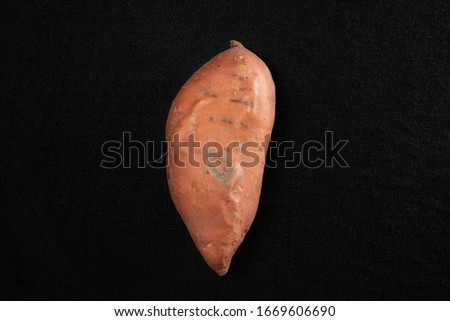 Still earthy sweet potato on a black background Royalty-Free Stock Photo #1669606690