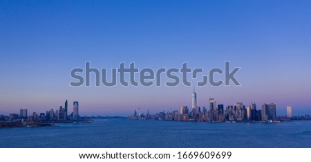 Aerial view of Manhattan waterfront and Jersey City from Hudson River at dusk, Panoramic, New York