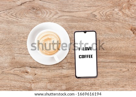 Phone and coffee on a vintage wooden background. Technology concept background. White screen phone copy space. Concept photos of desks / commercial backgrounds.