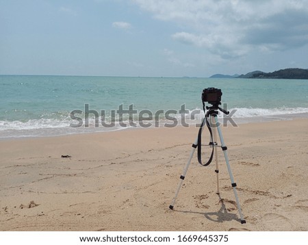 camera on sandy beach. Travel concept background.Take photos of the sea and the sky on a summer holiday.