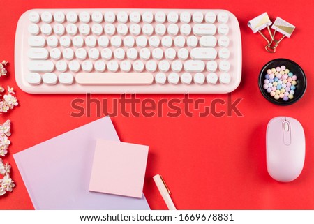 flat lay stationery on work desk in red pastel background	
