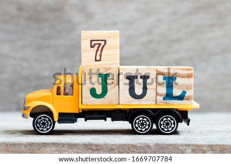 Truck hold letter block in word 7jul on wood background (Concept for date 7 month July)