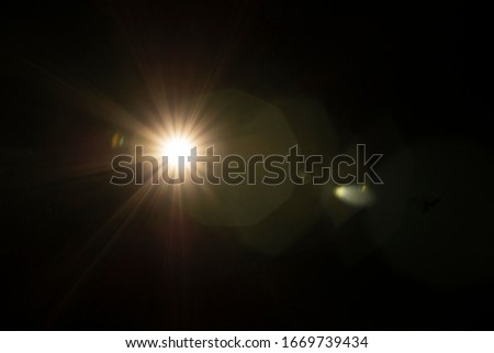 Lens Flare effect close up. Different colors (green, red, white, yellow) light over black background. Abstract sun burst. Easy to add overlay or screen filter over photos and images. Copy space.
