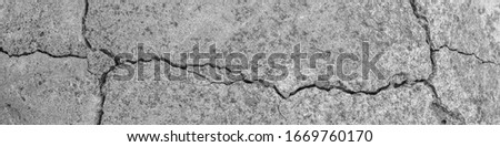 Concrete with crack broken in floor wall texture. Chapped surface asphalt old cement stone. Natural destruction from time and weather conditions. Non-color, monochrome black and white photo. Panorama
