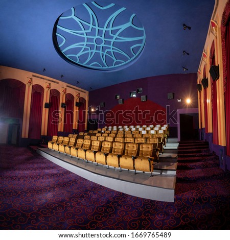 Large cinema theater interior with seat rows for audience to sit in movie theater premiere by cinematograph projector. The cinema theater is decorated in classical for luxury feel of movie watching. Royalty-Free Stock Photo #1669765489