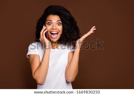 Close up photo of crazy funny afro american youth girl talk smart phone with friend impressed big bargain information scream wow omg wear white t-shirt isolated over brown color background