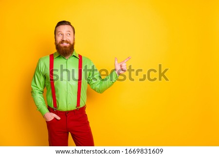 Photo of attractive hipster guy indicate finger empty space presenting black friday shopping season opening wear green shirt red suspenders pants isolated bright color background