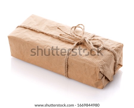 Gift box wrapped with white paper and burlap ribbon isolated on white background. A modern gift for any holiday.