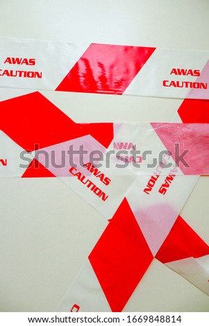 Red caution warning tape with white background.