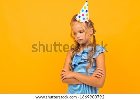 Beautiful girl with long hair has a birthday today, picture isolated on yellow background