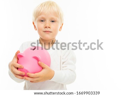 Little beautiful boy with blonde hair holds a moneybox, picture isolated on white background