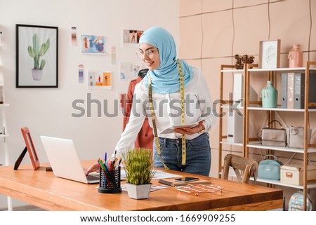 Female Muslim clothes stylist working in office