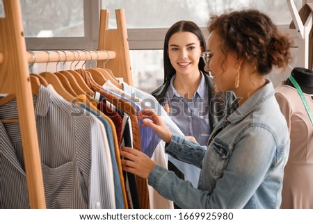 Female clothes stylist with client working in office Royalty-Free Stock Photo #1669925980