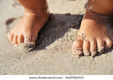 Child legs on sand texture.