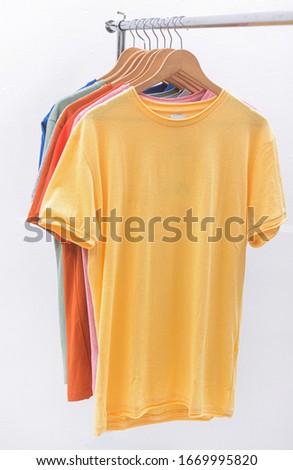  fashion concept. Hanger with row of colorful t-shirts 
on hanging

