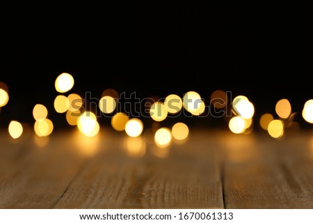 Wooden table and festive lights. Bokeh effect