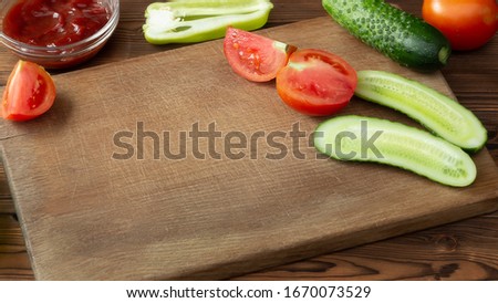 Wooden cutting board with tomatoes, cucumbers and empty space