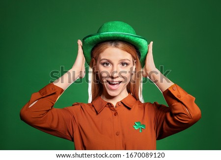 Young woman in green hat on color background. St. Patrick's Day celebration