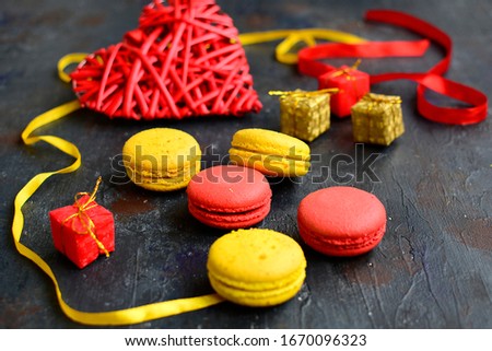 Composition of multi-colored macaroons and ribbons on a dark blue background. Holiday Concept. Close-up