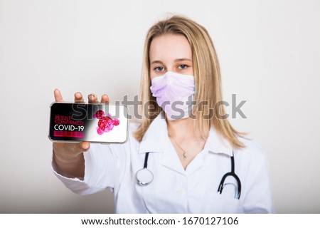 physician introduces innovative self test app for corona virus and covid 19 identification. portrait of young medic with smart phone isolated against white background Royalty-Free Stock Photo #1670127106