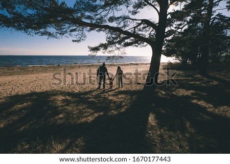 family walks on the Gulf of Finland at sunset