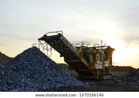 Mobile Stone Jaw crusher machine for crushing concrete into gravel and subsequent cement production. Salvaging and recycling of the demolition construction waste on landfill. Reuse concrete. Royalty-Free Stock Photo #1670186146