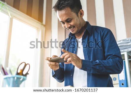 Asian man take a photo of product by smartphone to advertise sell in website.