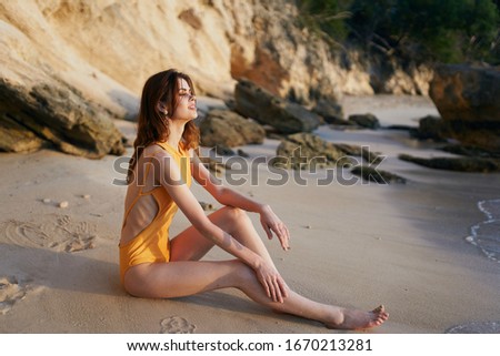 young woman with a beautiful figure in a swimsuit on the beach