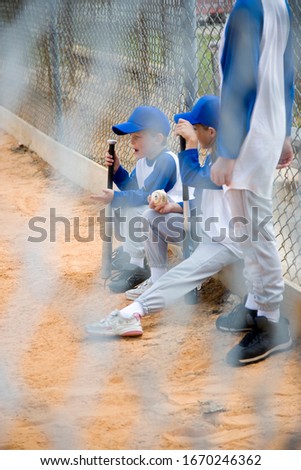A baseball team seeing through a wire fence