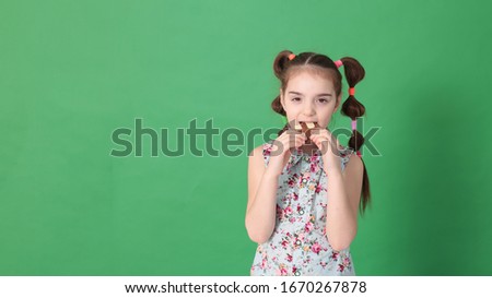 portrait of a young funny girl of eight years old with a funny hairstyle in a good mood