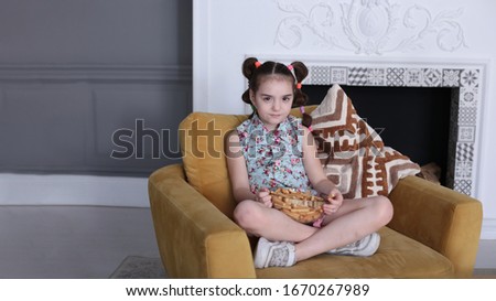 portrait of a young funny girl of eight years old with a funny hairstyle in a good mood