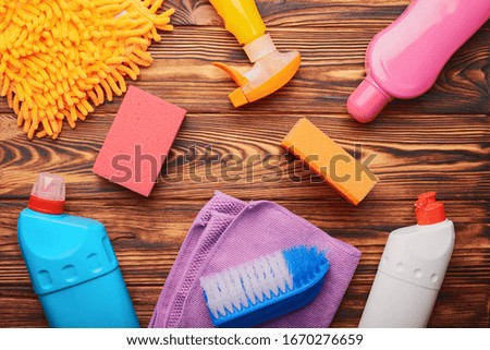 Top view of items and means for washing and cleaning on a wooden background.