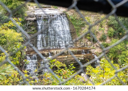 a waterfall from behind a fence