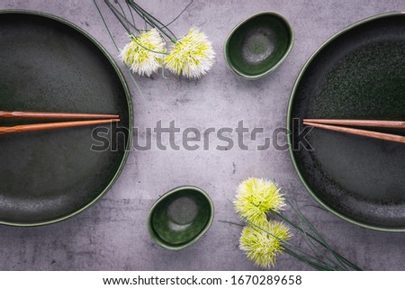 Empty plates for sushi on grey background. Plates, soy sauce bowl and chopsticks. Oriental table set up. Asian restaurant menu. Copy space, top view
