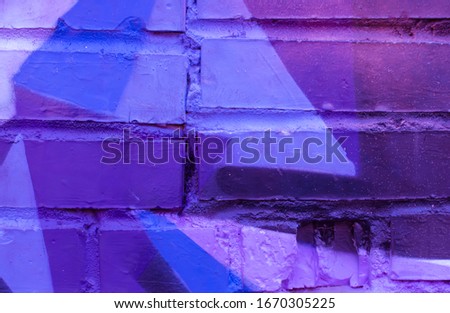 Beautiful bright colorful street art graffiti background. Abstract creative spray drawing fashion colors on the brick walls of the city. Urban Culture ,blue, purple , violet , neon texture