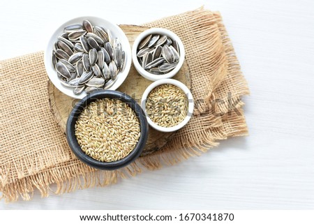 birdseed and natural sunflower seeds, food for birds, displayed in containers on cloth background