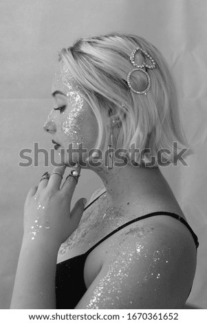 photo from the model's profile with glitter on the face and a hair clip