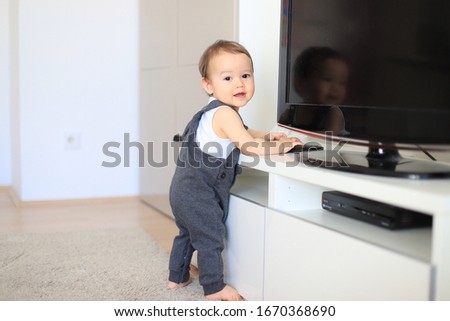 Little baby boy learning how to stand and walk at home. Cute mixed race Asian-German infant about 9-10 months old. Healthy newborn child. Royalty-Free Stock Photo #1670368690