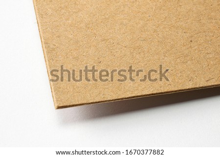 Blank craft textured cardboard paper corner macro view selective focus on white as template for logo presentation, embossing etc.