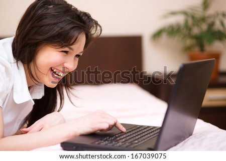 Young woman is playing on laptop, indoor shoot