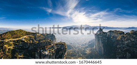 Aerial view of monastery Trinity and breathtaking pictures of valley and landmark canyon of Meteora at sunset, Kalambaka, Greece, shadows, twisted road, bridge, Mountains as columns
