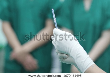 Syringe in hands. Doctor preparing syringe for patient in operation room.