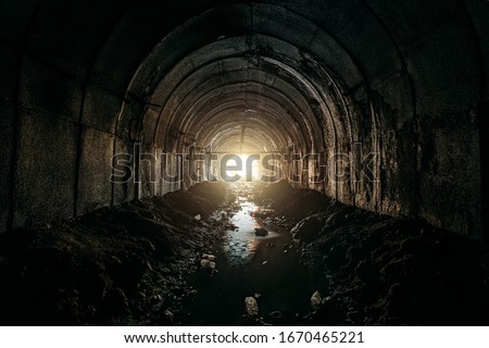 Light at the end of dirty sewer tunnel Royalty-Free Stock Photo #1670465221