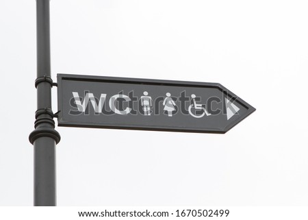 arrow pointer showing the direction to the public toilet, the road sign is on the street on a white background