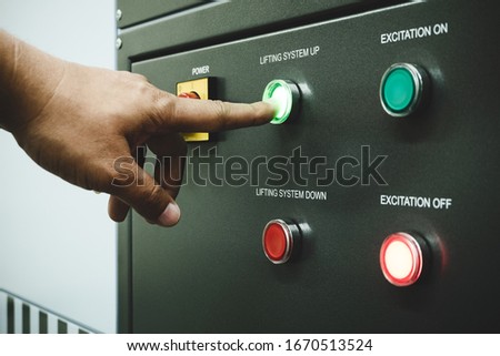 Male operator using point finger to push green button to operate Test machine