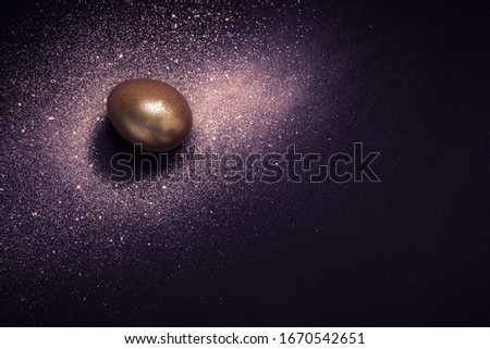Golden egg and paint spray Galaxy on purple background. Abstract cosmos. Happy easter concept.
