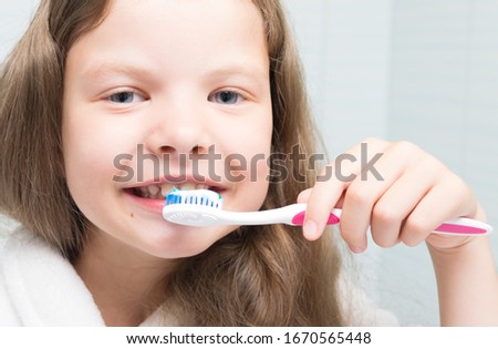 close-up, a girl with long hair, brushing her teeth with a brush and paste